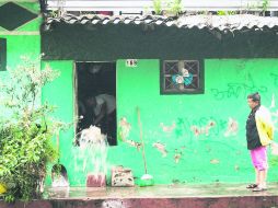 Habitantes de una de las casas afectadas por la inundación en la colonia El Deán sacan el agua a cubetazos. EL INFORMADOR / S. BLANCO