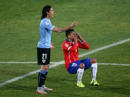 El delantero uruguayo Edinson Cavani (izq.) y Gonzalo Jara (der.) momentos después de que Cavani reaccionara a la ofensa del chileno. AFP / ARCHIVO