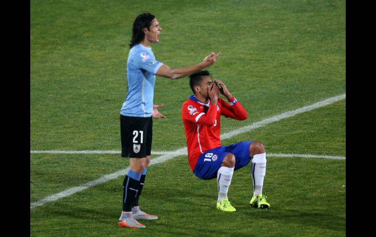 El delantero uruguayo Edinson Cavani (izq.) y Gonzalo Jara (der.) momentos después de que Cavani reaccionara a la ofensa del chileno. AFP / ARCHIVO