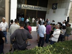 Los residentes y turistas tratan de retirar dinero en efectivo antes del cierre temporal de los bancos y el control de capitales. EFE / A. Vlachos