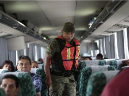 Un soldado inspecciona un autobús de pasajeros como parte del operativo para la recaptura de Guzmán Loera. AFP / P. Pardo