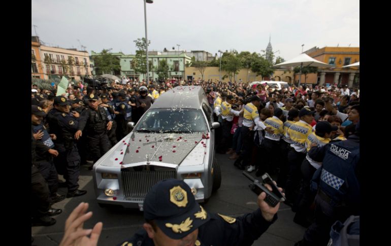 Policías evitan que los fans toquen la carroza que transporta los restos del cantautor el jueves 16 de julio, en la Ciudad de México. AP / ARCHIVO