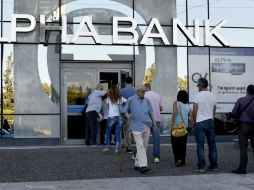 Largas filas de cuentahabientes se forman a la entrada de las sucursales bancarias, sin más problemas. AFP / A. Messinis