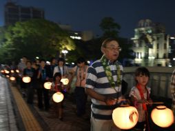 Ciudadanos de Hiroshima llevan linternas durante una procesión para confortar las almas de las víctimas de la bomba. AFP / K. Nogi