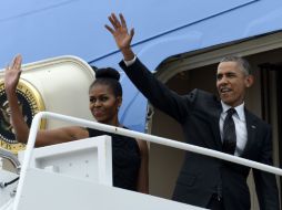 Barack, su esposa Michelle y sus hijas Sasha y Malia abordan el avión presidencial un día antes de lo planeado. AP / S. Walsh