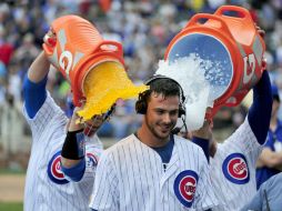 David Ross y Anthony Rizzo arrojan bebidas y hielo a Kris Bryant cuanto el héroe del juego habla para la televisión. AFP / D. Banks