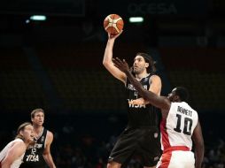 El argentino Luis Scola realiza un tiro al aro ante la marca del canadiense Anthony Bennett, durante el partido de ayer. EFE / J. Méndez