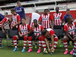 Héctor Moreno (izq) ve a la cámara, mientras Guardado se ajusta el zapato previo a la foto oficial del PSV. ESPECIAL / PSV Media