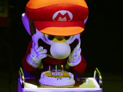 Una botarga de 'Super mario' sopla las velas colocadas sobre una tarta. AFP / T. Kitamura