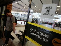 Turistas del país y extranjeros se encuentran varados en el aeropuerto internacional de Santiago por la cancelación de los vuelos. EFE / M. Ruiz