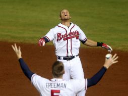 Andrelton Simmons celebra con Freddie Freeman tras conectar el sencillo que le dio por fin el triunfo a los Bravos como locales. AP / J. Bazemore