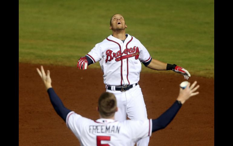 Andrelton Simmons celebra con Freddie Freeman tras conectar el sencillo que le dio por fin el triunfo a los Bravos como locales. AP / J. Bazemore