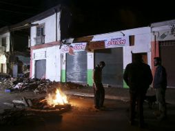 Cientos de personas pasaron la noche afuera de sus destruidos hogares y locales comerciales, ante fogatas para paliar el intenso frío. EFE / M. Ruiz