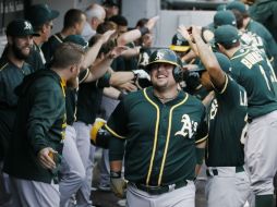 Billy Butler es felicitado por sus compañeros después de conectar el jonrón que le dio el triunfo a los Atléticos de Oakland. AP / A. Nelles