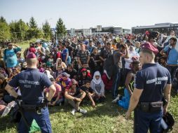 La policía vigila a un grupo de inmigrantes en la frontera entre Hungría y Croacia en la localidad de Beremend. EFE / B. Mohai