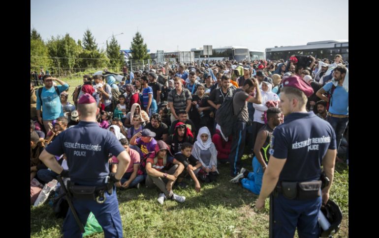 La policía vigila a un grupo de inmigrantes en la frontera entre Hungría y Croacia en la localidad de Beremend. EFE / B. Mohai