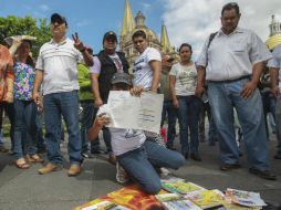 Los inconformes se plantaron en la explanada de Palacio de Gobierno para mostrar la ficha bibliográfica de los ejemplares. EL INFORMADOR / F. Atilano