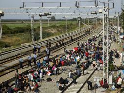 Policías vigilan a los desplazados que esperan en la estación de ferrocarril de Tovarnik, Croacia Oriental. EFE / Z. Balogh