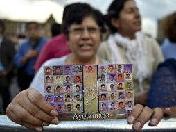 Una mujer muestra una imagen de los 43 estudiantes desaparecidos, en apoyo a los padres de los normalistas. AFP / Y. Cortez