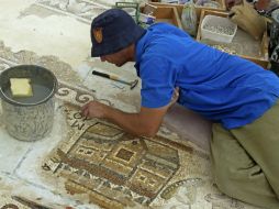 La pieza muestra imágenes de edificios ordenados a lo largo de una calle con columnas, lo que sería una especie de mapa antiguo. EFE /