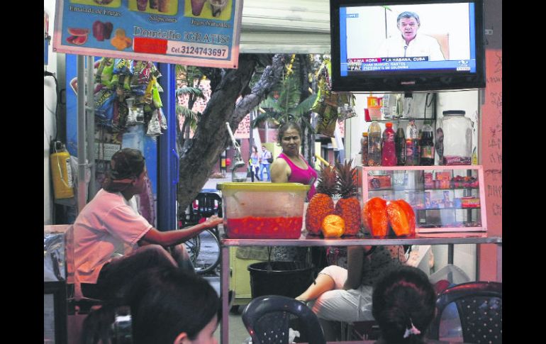 Colombianos siguen la trasmisión televisiva en Medellín del anuncio sobre el proceso de paz con los guerrilleros. EFE / ARCHIVO