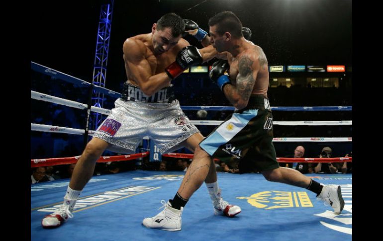 NUEVO CAMPEÓN. Viktor Postol (izq.) golpea de zurda la cara del argentino Lucas Matthyse. AFP / J. Gross