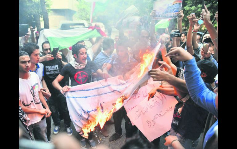 Manifestantes queman imitación de bandera israelí en apoyo a palestinos frente a la embajada en El Cairo. EFE /