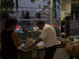 Gente guarda artículos de una tienda ante la llegada del huracán ''Patricia''. AP / C. Rodríguez