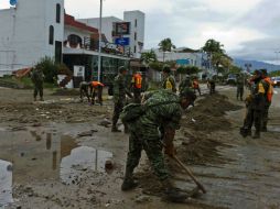 Después del paso del huracán, autoridades de Manzanillo recogen los escombros que obstaculizan las calles de la ciudad. AFP / O. Torres