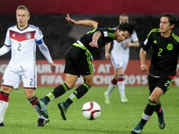 Los jugadores de México Alan Cervantes y Diego Cortés, disputan un balón con Felix Passlack. EFE / B. Hernández