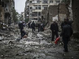 Ciudadano sirios observan los daños tras un bombardeo contra un hospital en Damasco. EFE / M. Badra