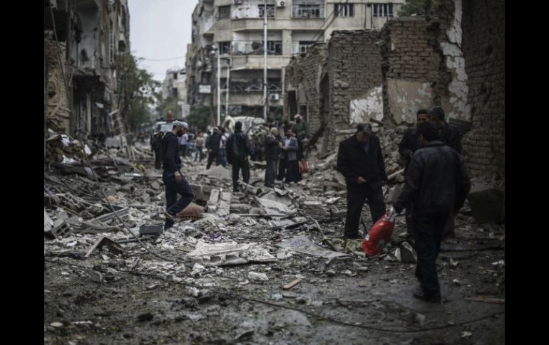 Ciudadano sirios observan los daños tras un bombardeo contra un hospital en Damasco. EFE / M. Badra