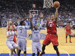 DeMar DeRozan, guardia de los Raptors, se levanta para encestar ante la mirada de tres jugadores de Orlando. AP / J. Raoux