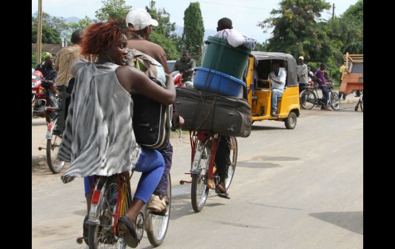 Ante la violencia, vecinos de Buyumbura huyen a bordo de sus bicicletas con todo lo que pueden cargar consigo. AP /