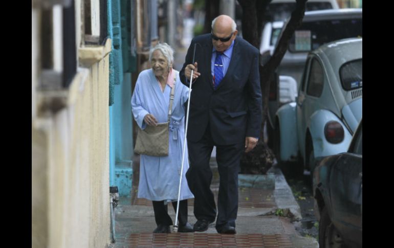 Sebastián Anguiano Manzano ha sufrido varias caídas por el estado de las aceras; en la foto lo acompaña su amiga María del Socorro. EL INFORMADOR / F. Atilano