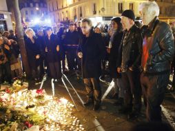 Los integrantes de U2 colocan flores a las afueras del Bataclan, uno de los lugares en donde ocurrieron los atentados. EFE / M. Christians