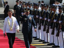 El presidente pasa revista a la guardia de honor a su llegada a la base aérea militar de Manilas. AFP / T. Aljibe