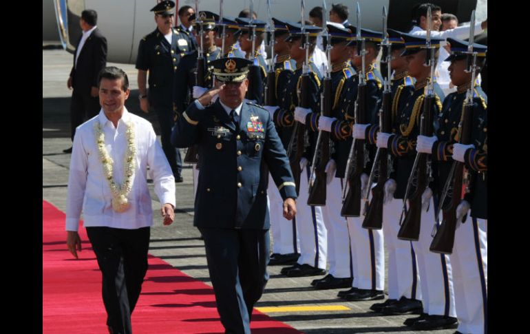 El presidente pasa revista a la guardia de honor a su llegada a la base aérea militar de Manilas. AFP / T. Aljibe