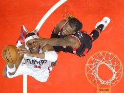 Paul Pierce (izq.), de los Clippers, intenta encestar ante la marca de DeMarre Carroll, de los Raptors, durante el partido de ayer. AP / M. Terrill