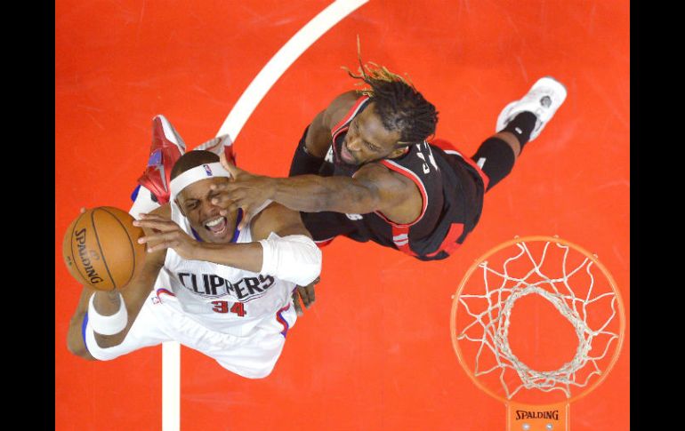 Paul Pierce (izq.), de los Clippers, intenta encestar ante la marca de DeMarre Carroll, de los Raptors, durante el partido de ayer. AP / M. Terrill