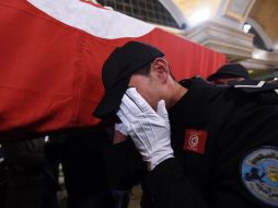 Un agente de policía llora junto al atúd de un guardia presidencial muerto por el acto terrorista. AFP / F. Belaid