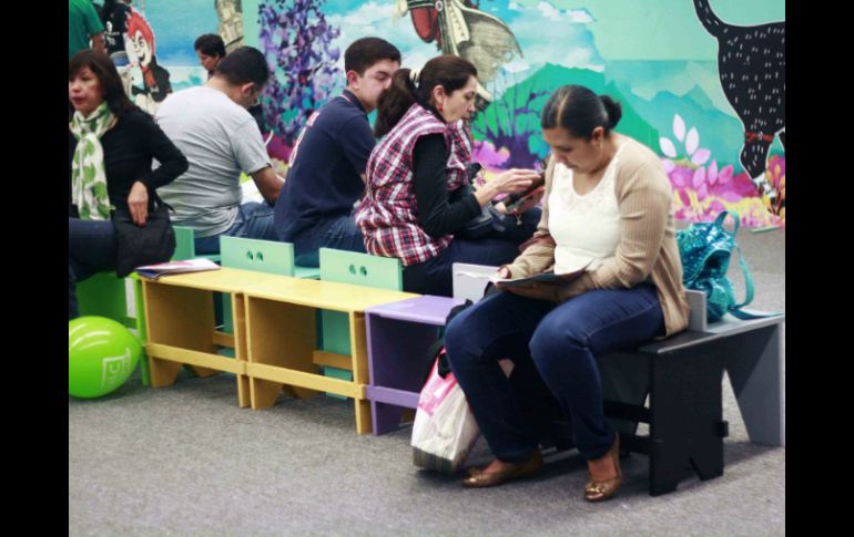 Mientras esperan a sus hijos, padres aprovechan los libros que se encuentran en el lugar. ESPECIAL / Mar Adentro