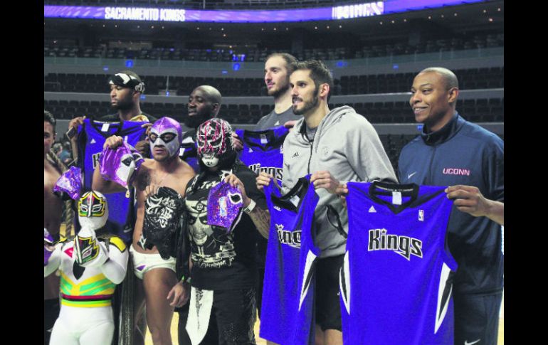 Jugadores de los Kings de Sacramento posan junto a luchadores mexicanos tras su práctica de ayer. EFE / M. Guzmán