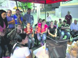 Vecinos de Caracas esperan los primeros resultados tras las elecciones legislativas de ayer, en Venezuela. AP /