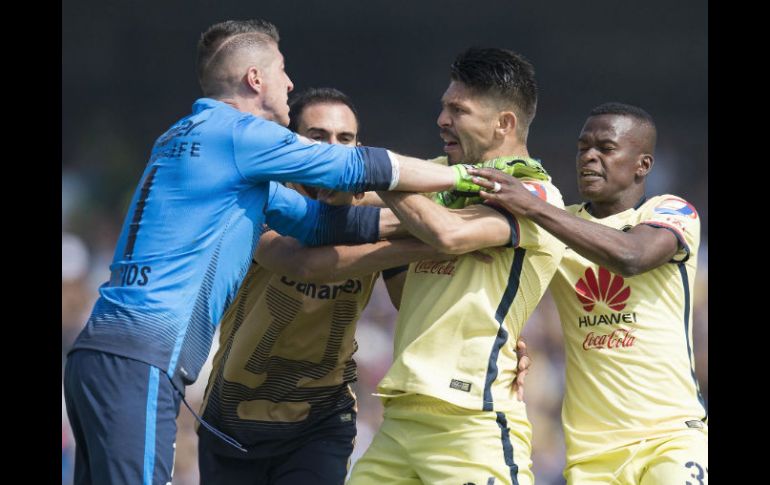 El portero de Pumas, Alejandro Palacios (izq) forcejea con el delantero del América, Oribe Peralta, durante el juego de ayer. MEXSPORT / D. Leah