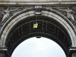 Un ecologista se colgó a 30 metros de altura con banderas amarillas donde se leía: ''Hollande, renueve la energía''. AFP / M. Bureau