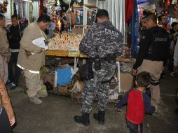 Policías tapatíos revisan los puestos en búsqueda de fuegos pirotécnicos. ESPECIAL /