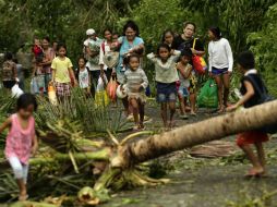 Familias desalojan la ciudad de Juban para trasladarse a un refugio. EFE / F. Malasig