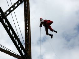 El experto en cabuyería y rapel se lanzó del puente haciendo el clásico 'Jo jo jo' del personaje navideño. EFE / E. Biba