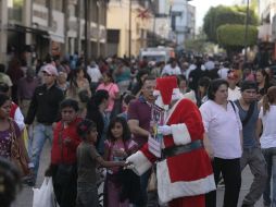 Santa se abre paso para saludar a los más pequeños entre la multitud que cubre las calles del Centro Histórico. EL INFORMADOR / R. Tamayo